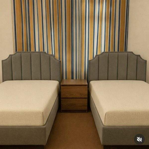 Homefactree Twin Haven upholstered single bed set with two grey fabric beds, vertical panel headboards, decorative nailhead trim, and a shared wooden bedside table.
